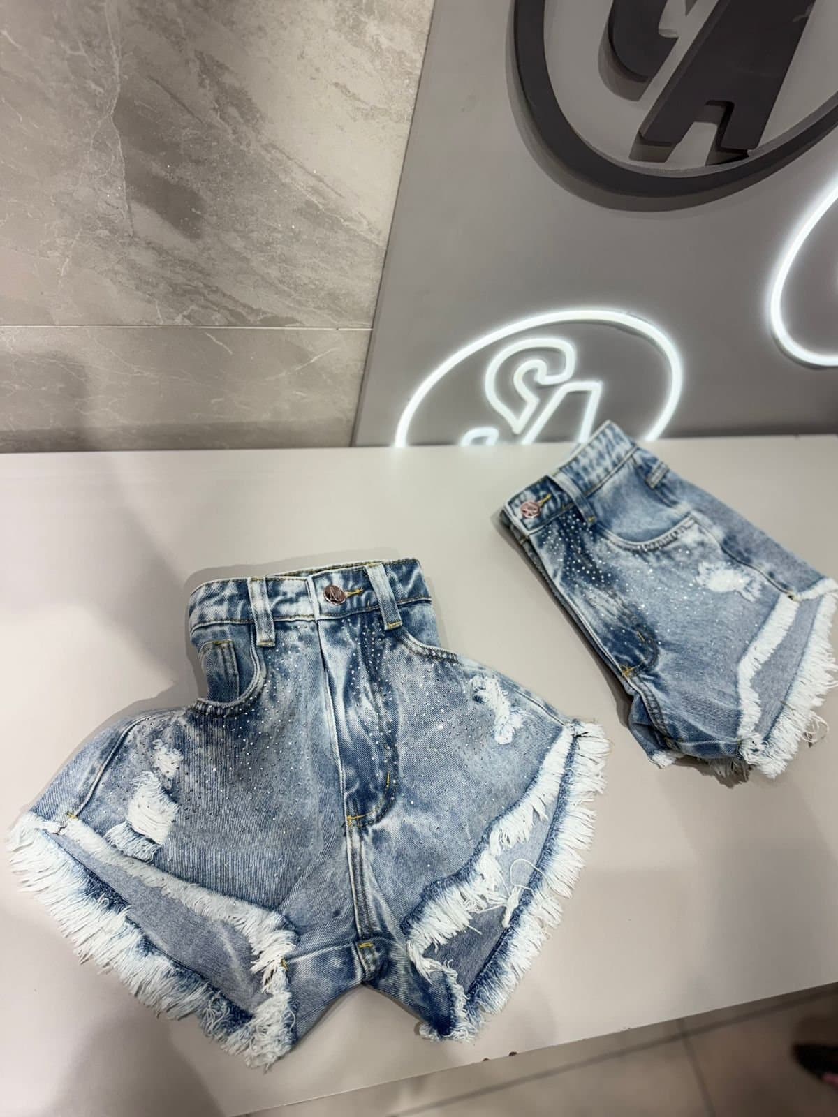 Shorts Jeans Sensação com Strass Barra Desfiada